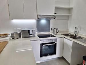 巴利托Simbithi Golf Estate Luxury Apartment的厨房配有白色橱柜和炉灶烤箱。