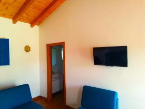 圣路易斯VALE DE GAIOS - CASARÃO by Stay in Alentejo的客房设有2把蓝色椅子和平面电视。