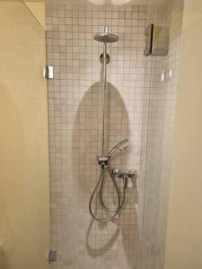 穆尔滕Elegant Suites Murten的带淋浴的浴室(带瓷砖墙)