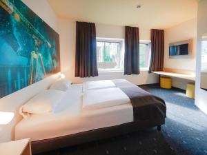 耶拿B&B Hotel Jena的卧室设有白色大床和窗户。