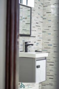 内罗毕Ushindi Bronx Villas的浴室设有白色水槽和镜子