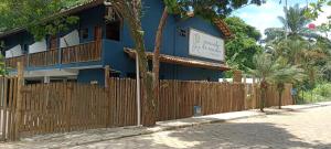 伊塔卡雷Pousada Caminho da Concha的前面有栅栏的蓝色建筑