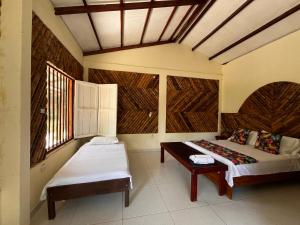 El ValleHotel Kipara el Valle的一间卧室配有两张床和一张桌子