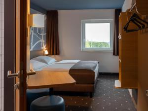 劳森豪森B&B HOTEL Frankfurt-Hahn Airport的酒店客房设有床和窗户。