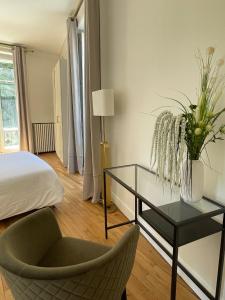 伊居利Grand appartement d'exception au Château Randin的卧室配有1张床、1张桌子和1把椅子