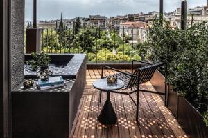 雅典The Modernist Athens的阳台配有桌子和椅子,位于甲板上