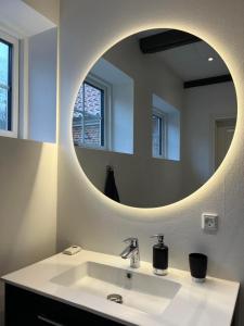 Dragsgaard Herregård的一间带水槽和圆形镜子的浴室