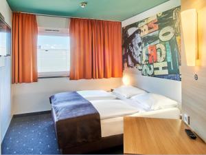 美因茨美因茨海彻斯黑姆住宿加早餐酒店的酒店客房设有床和窗户。