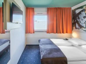 美因茨美因茨海彻斯黑姆住宿加早餐酒店的酒店客房设有两张床和窗户。