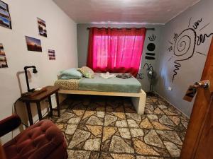 Bajo BoqueteBoho by Arte Hostal Boquete的一间卧室配有一张床和一个粉红色的窗户
