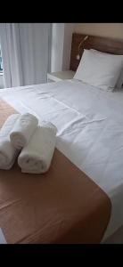 巴西利亚VISION Flat Particular Varanda Garagem Piscina Academia的一张白色的床,上面有两张折叠毛巾
