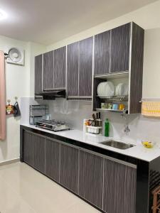 莎阿南Igo homestay - Family Room的厨房配有木制橱柜和台面