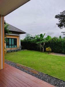 Suen PhraHana Villa Hatyai的后院,带草坪和房子