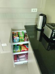 Suen PhraHana Villa Hatyai的厨房柜台配有带食品的冰箱