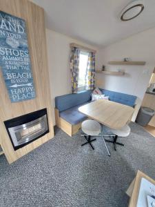 克利索普斯Haven holiday park Cleethorpes beach的客厅配有蓝色的沙发和桌子