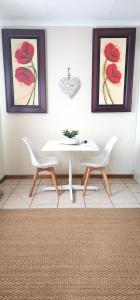 LobambaCottage @ Ezulwini的一间配备有白色桌子和两把椅子的用餐室