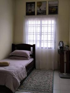 巴西古当Homestay Cikgu的一间卧室设有床、窗户和地毯。