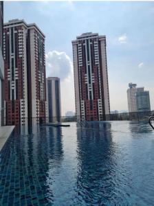 吉隆坡Chamber Laboni Suite kl的两个高楼前的游泳池