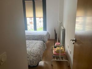 哈卡Modern & cosy Apartment in Jaca Pyrenees Spain的一间设有两张床的房间,里面装有行李车