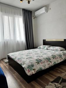 桑丹斯基Apartment Alex的一间卧室配有一张带花卉棉被的床和窗户。