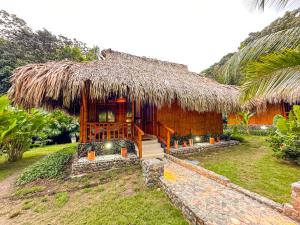 埃尔扎伊诺Ecohabs Bamboo Parque Tayrona - Dentro del PNN Tayrona的茅草屋顶和外部楼梯的房子