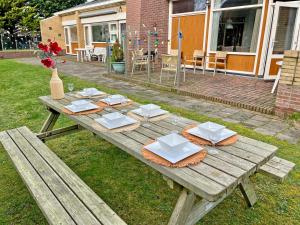 海滨诺德韦克Beach House Wantveld Noordwijk aan Zee的一张木餐桌,上面有盘子和餐巾