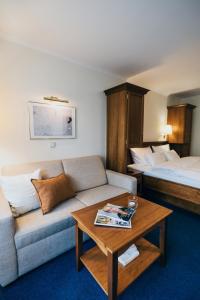巴特法兴格Hotel Reindl Suiten & Appartments的酒店客房设有一张沙发和一张床