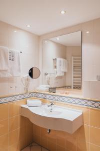 巴特法兴格Hotel Reindl Suiten & Appartments的一间带水槽和镜子的浴室