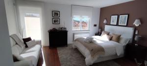 阿维拉EL PATIO DE MI CASA的卧室配有白色的床和白色沙发