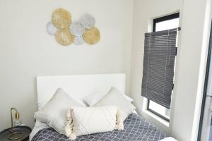 米德兰Cozy Hidden gem in Midrand的卧室配有带枕头的床铺和窗户。