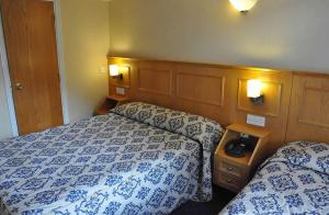 伦敦奥林匹克之家酒店 的酒店客房带两张带蓝白床单的床。