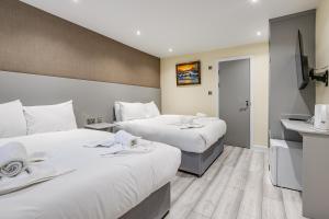 伦敦贝尔蒙特&阿斯托里亚酒店的酒店客房设有两张床和盥洗盆