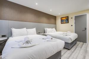 伦敦贝尔蒙特&阿斯托里亚酒店的两张位于酒店客房的床,上面有白色毛巾