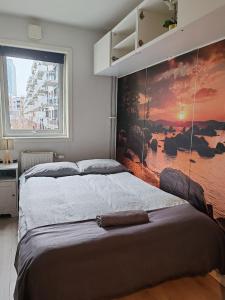 奥斯陆Central and cozy next to Oslo S的卧室配有一张大床,墙上挂有绘画作品