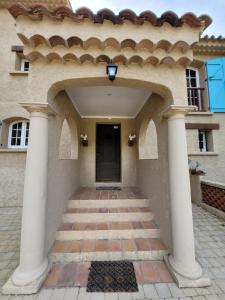 勒·雷约尔·卡纳德尔·苏尔Rayol Villa Saphir的进入有柱子和门的房子的入口