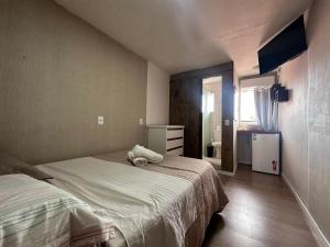 弗洛里亚诺波利斯Recanto da Sol的一间卧室配有一张床、梳妆台和镜子