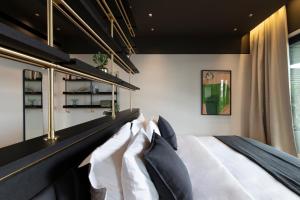雅典The Modernist Athens的一间卧室配有一张带黑白枕头的床