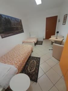 卡拉尔佐Lunga Via Delle Dolomiti的客房设有三张床、一张桌子和一张书桌