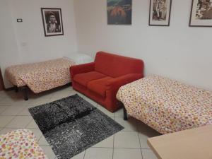 卡拉尔佐Lunga Via Delle Dolomiti的客厅配有红色沙发和两把脚凳