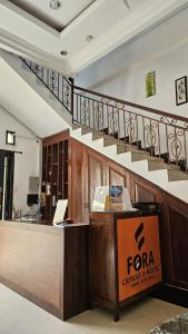 库塔Fora Capsule Hostel Tuban Kuta Bali的大堂设有前台和楼梯