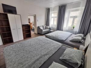亚希莫夫Apartmány Cipriani的一间卧室配有两张床、一台电视和一张沙发