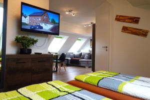 HerresbachSpeedys Apartments am Brünnchen的卧室设有壁挂式电视和床。