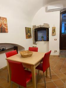夏卡Casa Carini的一间带木桌和红色椅子的用餐室