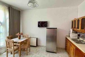 赫尔格达Palma de Meritee villa 2 apartment 4 village veiw的厨房配有桌子和不锈钢冰箱。