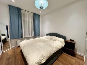 鹿特丹Cozy Corner in Rotterdam的卧室设有一张大床,卧室设有大窗户