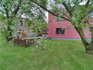 奥茨塞巴德·迪尔哈根Pension Stocker的粉色建筑旁的院子的长凳