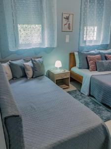 KalithiesPapa’s house的一间蓝色卧室,配有两张床和一张沙发