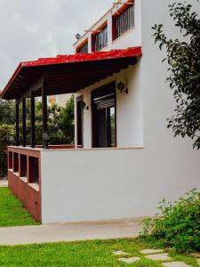 KalithiesPapa’s house的一座白色的小建筑,有红色的屋顶和草