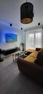 莱格尼察Apartament JB 56m2 parking,balkon,2sypialnie的带沙发和平面电视的客厅