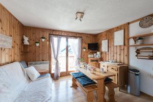 圣热尔韦莱班Ski ou Thermes? Un appt cabine avec vue magnifique的客厅设有木墙和桌子